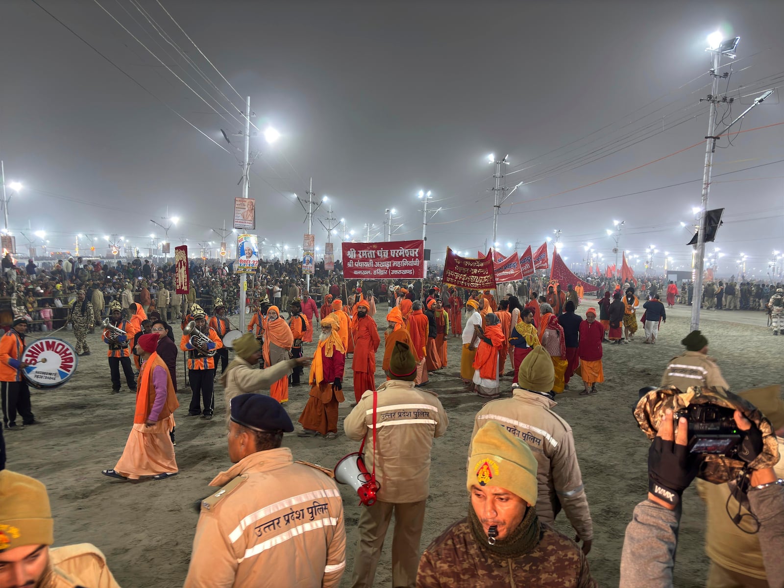 Hindus wait for a holy procession at the confluence of the Ganges, the Yamuna and the mythical Saraswati rivers on Makar Sankranti, an auspicious bathing day of the 45-day-long Maha Kumbh festival in Prayagraj, India, Tuesday, Jan. 14, 2025. (AP Photo/Ashwini Bhatia)