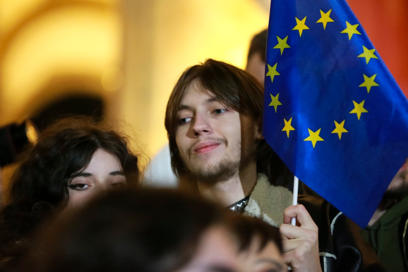 A young man holds an EU flag as he attends an opposition protest against the results of the parliamentary election in Tbilisi, Georgia, on Monday, Oct. 28, 2024. (AP Photo/Zurab Tsertsvadze)