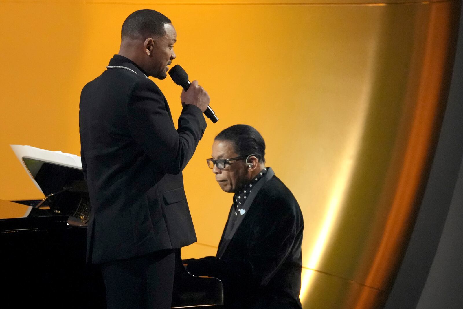 Will Smith, left, speaks while Herbie Hancock plays the piano during the 67th annual Grammy Awards on Sunday, Feb. 2, 2025, in Los Angeles. (AP Photo/Chris Pizzello)