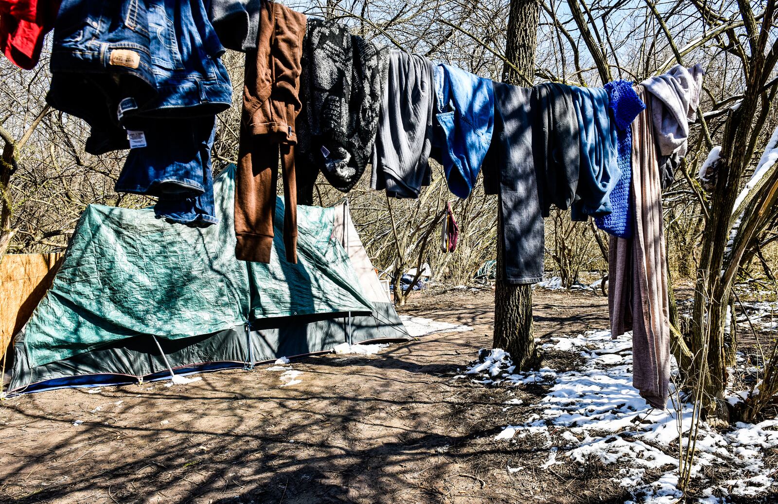 Tents are set up in a homeless camp behind Hamilton Plaza shopping center Thursday, March 22. 