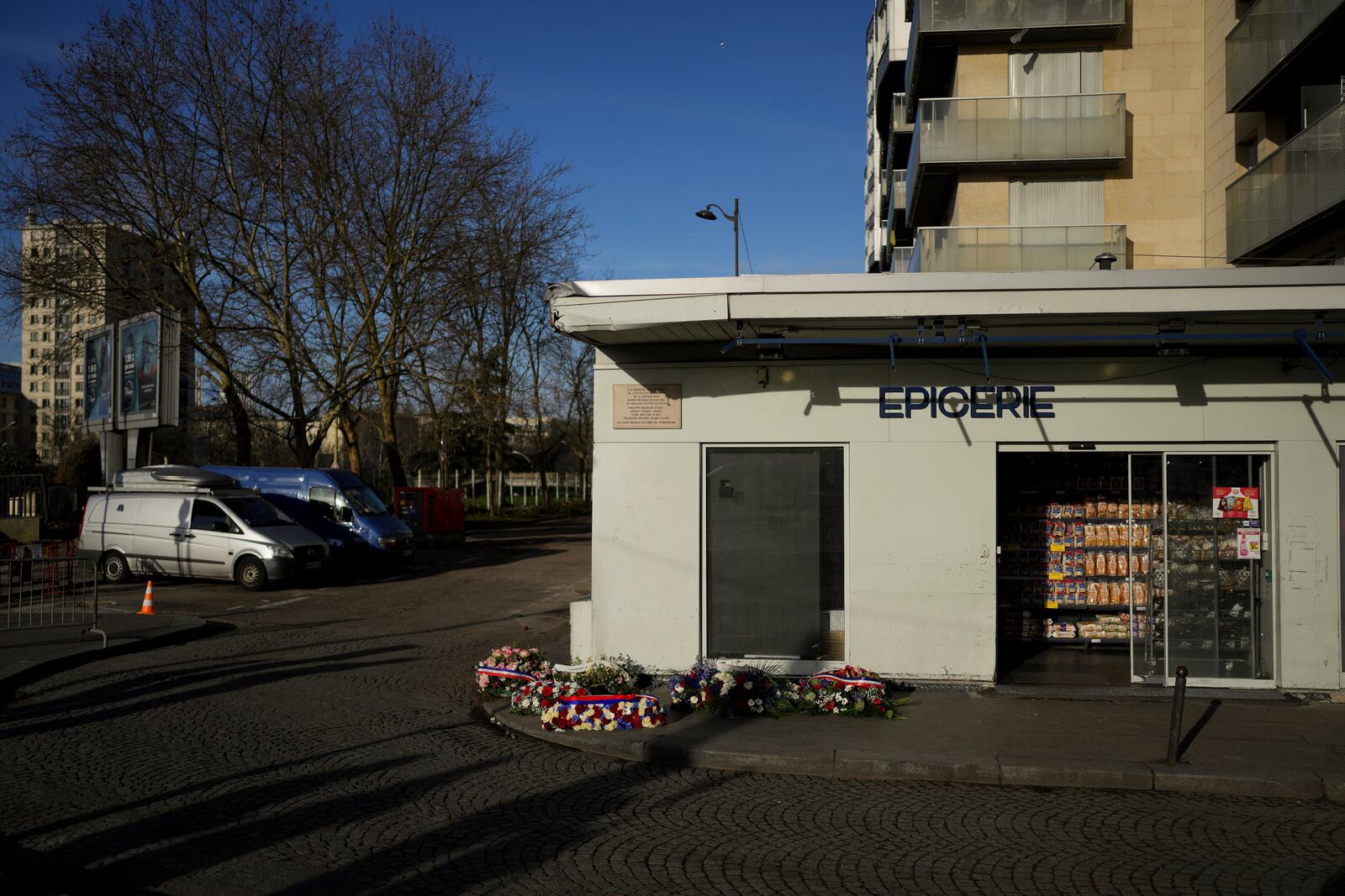 Wreaths lie in front of the Hypercacher Supermarket after commemorations marking 10 years since an Islamist attack on the Charlie Hebdo satirical newspaper and the Hypercacher jewish supermarket, in Paris Tuesday Jan. 7, 2025. (AP Photo/Thibault Camus)