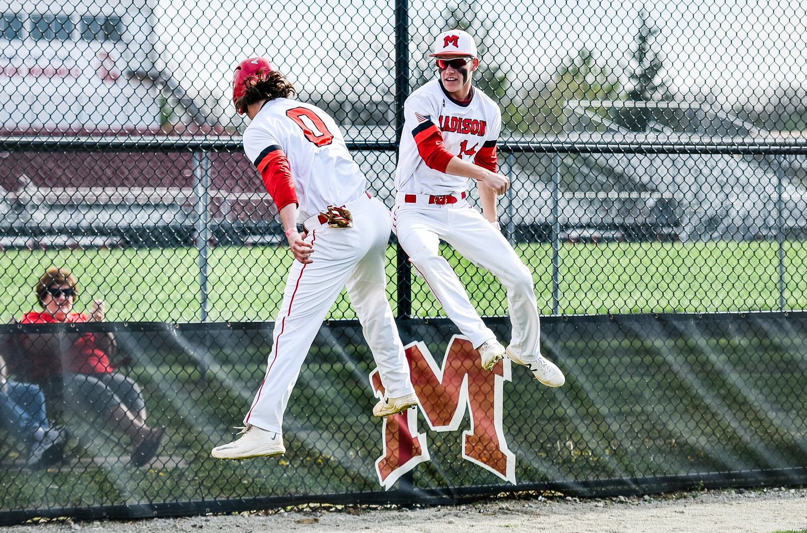 Madison’s Reid Davis (0) jumps to celebrate his run with teammate Noah Lehman (14) during Thursday’s game against Carlisle in Madison Township. NICK GRAHAM/STAFF