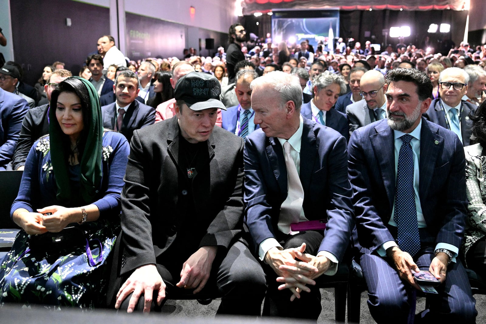 Elon Musk talks with former Google CEO Eric Schmidt as Governor of Public Investment Fund of Saudi Arabia Yasir Al-Rumayyan, right, listens before President Donald Trump speaks at the Future Investment Initiative (FII) Institute summit in Miami Beach, Fla., Wednesday, Feb. 19, 2025. (Pool via AP)