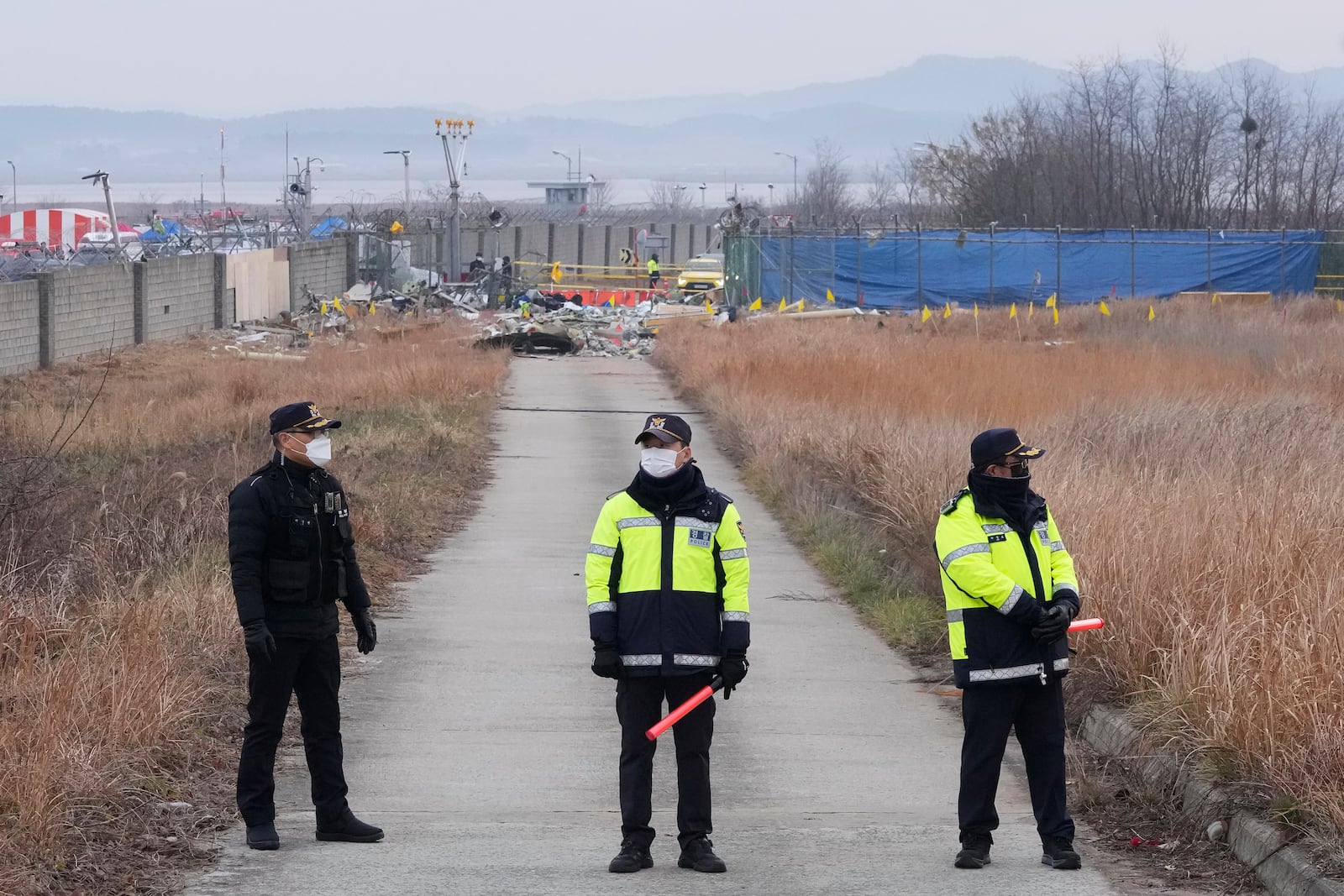 Police officers stand guard near the site of a plane fire outside of Muan International Airport in Muan, South Korea, Monday, Dec. 30, 2024. (AP Photo/Ahn Young-joon)