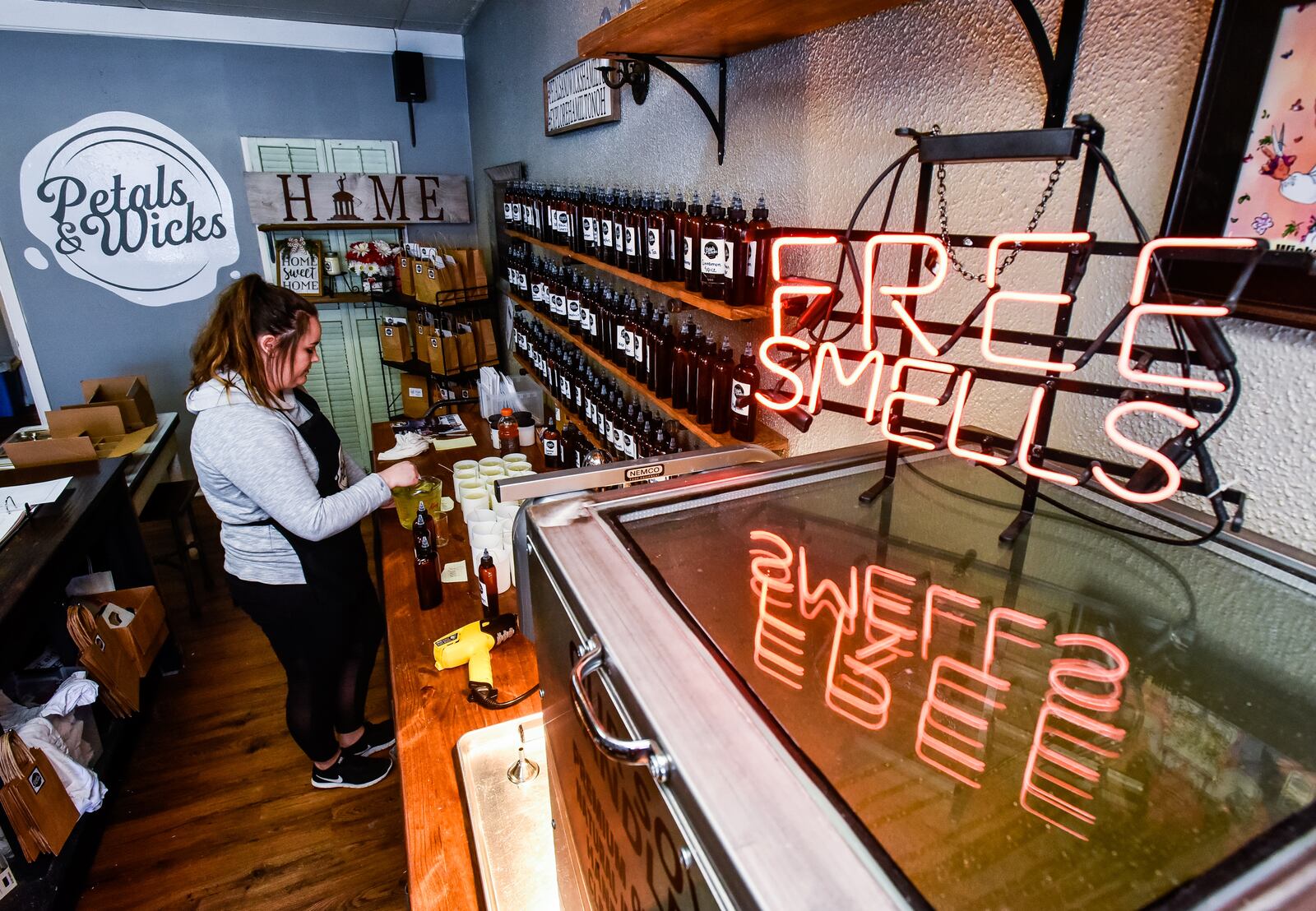 Taylor Hooker mixes fragrances and hot wax for candles at Petals & Wicks on Main Street in Hamilton Tuesday, April 2, 2019. Owner Sherry Hoskins recently expanded her candle business to add lotion, bath bombs, and other items to gear up for the opening of Spooky Nook Sports complex that is slated to open in 2021. NICK GRAHAM/STAFF