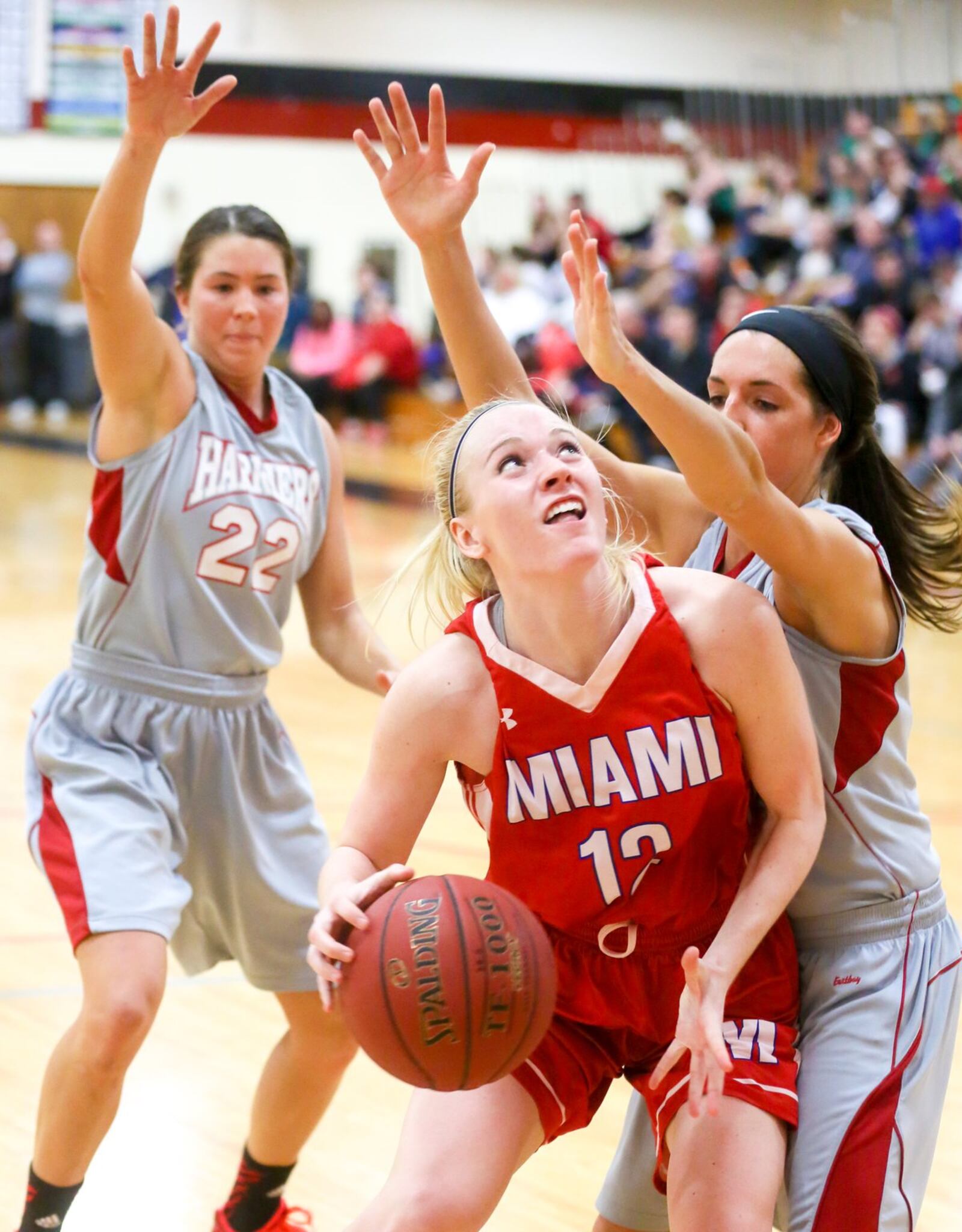 Miami Middletown guard Adrianna Moore (12) finds herself surrounded by Miami Hamilton’s Jillian Spurlock (22) and Staci Barrow on Wednesday night at MUH. GREG LYNCH/STAFF