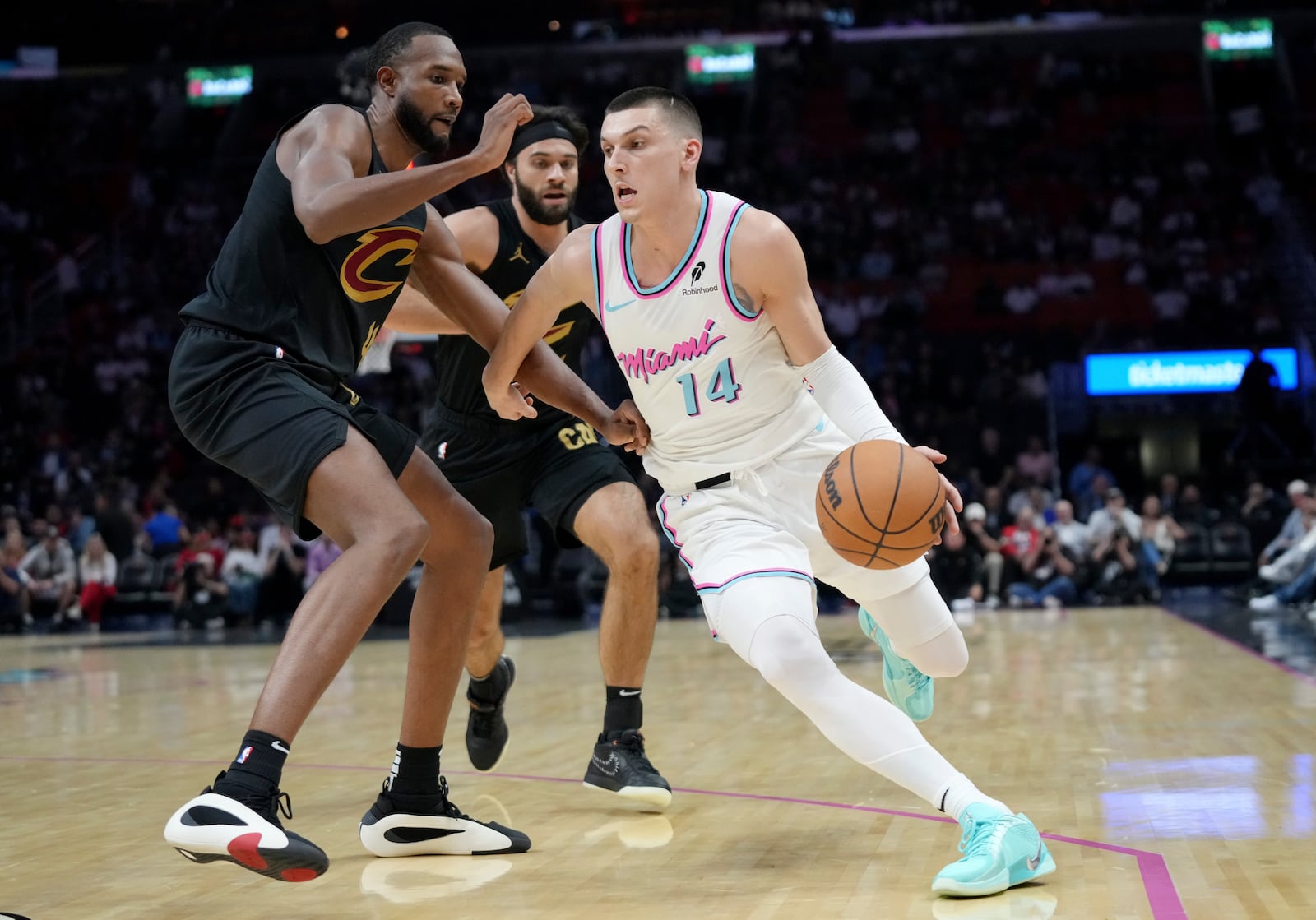 Miami Heat guard Tyler Herro (14) dribbles as Cleveland Cavaliers forward Evan Mobley, left, defends during the first half of an NBA basketball game, Wednesday, Jan. 29, 2025, in Miami. (AP Photo/Lynne Sladky)