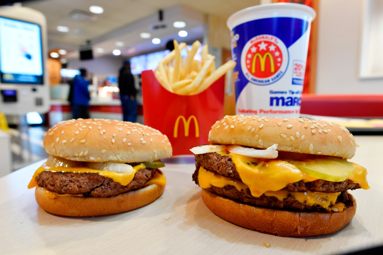 FILE- In this March 6, 2018, file photo, a McDonald's Quarter Pounder, left, and Double Quarter Pound burger is shown in Atlanta. (AP Photo/Mike Stewart, File)