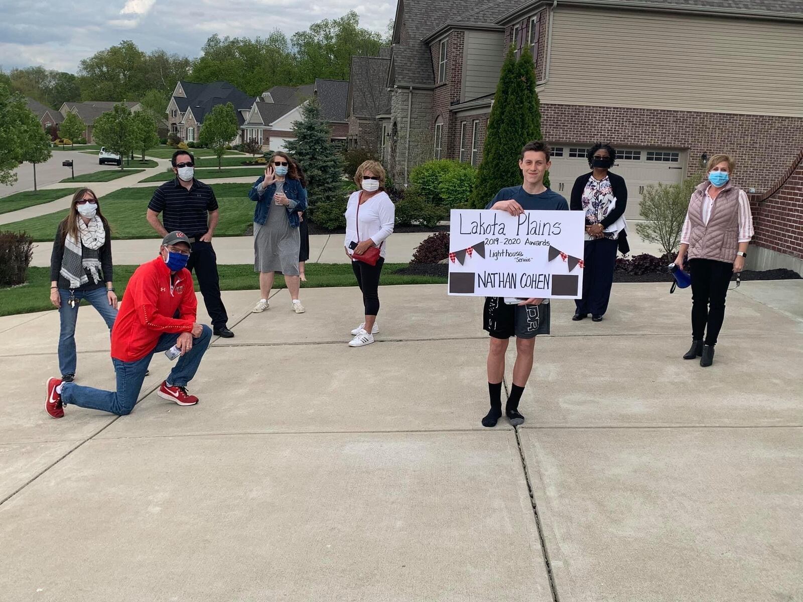 Lakota School officials home delivered a school award this week to a junior high student in Liberty Township as part of the district’s efforts to personalize the end of the school year during the coronavirus shutdown of classes. Nathen Cohen of Lakota’s Plains Junior School, was surprised by district officials who presented him the school’s Lighthouse Award for service at his home. (Provided Photo/Journal-News)