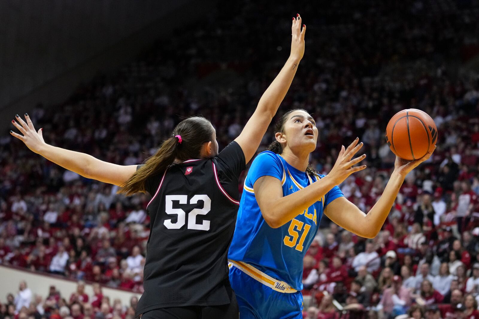 UCLA center Lauren Betts (51) shoots over Indiana forward Lilly Meister (52) in the second half of an NCAA college basketball game in Bloomington, Ind., Saturday, Jan. 4, 2025. (AP Photo/Michael Conroy)