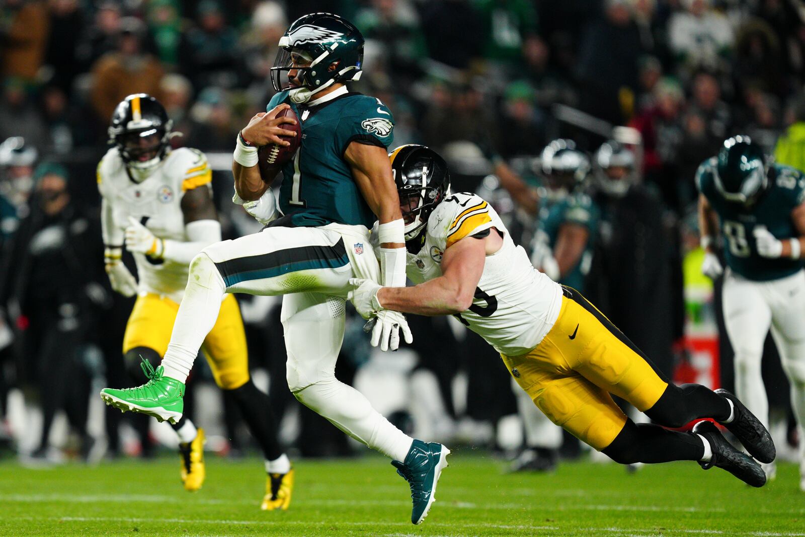 Philadelphia Eagles quarterback Jalen Hurts (1) is tackled by Pittsburgh Steelers linebacker T.J. Watt (90) during the second half of an NFL football game Sunday, Dec. 15, 2024, in Philadelphia. (AP Photo/Derik Hamilton)