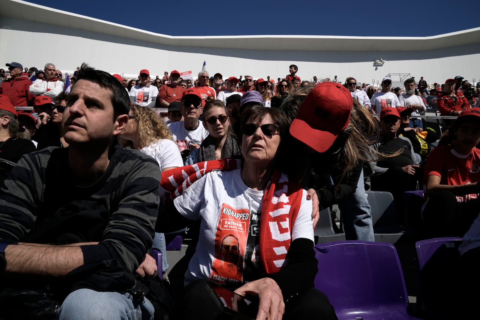 Dvora Idan, center, is comforted at a public memorial ceremony for her son, slain hostage Tsachi Idan, a fan of Hapoel Tel Aviv F.C., who was killed in Hamas captivity in the Gaza Strip, at Bloomfield Stadium in Tel Aviv, Israel, Friday, Feb. 28, 2025. (AP Photo/Leo Correa)