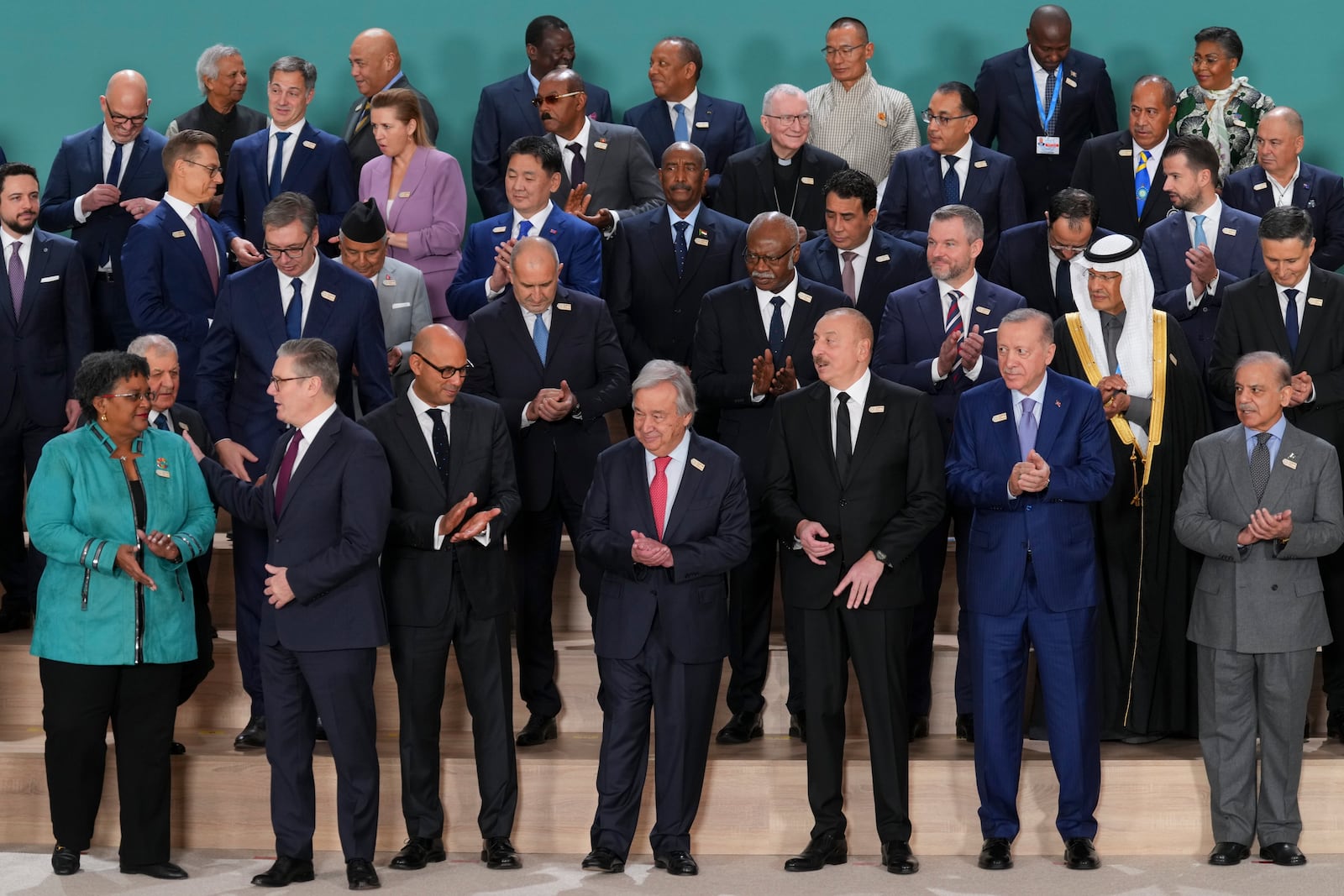 FILE - Barbados Prime Minister Mia Mottley, from front left, United Kingdom Prime Minister Keir Starmer, Simon Stiell, United Nations climate chief, Antonio Guterres, United Nations secretary-general, Ilham Aliyev, Azerbaijan president, Turkey President Recep Tayyip and Pakistan Prime Minister Shehbaz Sharif pose with others for a group photo at the COP29 U.N. Climate Summit, Tuesday, Nov. 12, 2024, in Baku, Azerbaijan. (AP Photo/Peter Dejong)