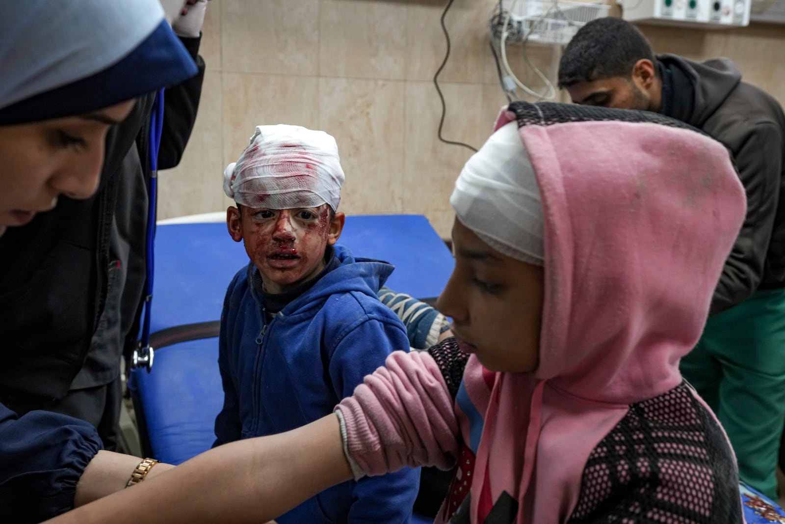 Palestinian children wounded during the Israeli bombardment of the Gaza Strip receive treatment at the Al-Aqsa Hospital in Deir al-Balah, Tuesday, Jan. 14, 2025. (AP Photo/Abdel Kareem Hana)