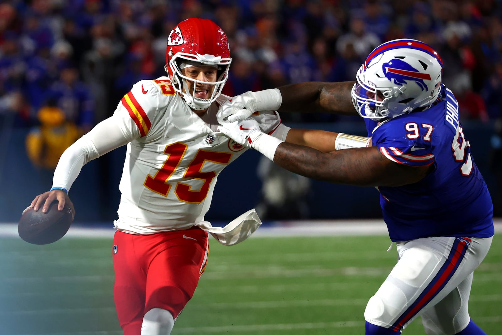 Kansas City Chiefs quarterback Patrick Mahomes (15) scrambles away from Buffalo Bills defensive tackle Jordan Phillips (97) during the second half of an NFL football game Sunday, Nov. 17, 2024, in Orchard Park, N.Y. (AP Photo/Jeffrey T. Barnes)