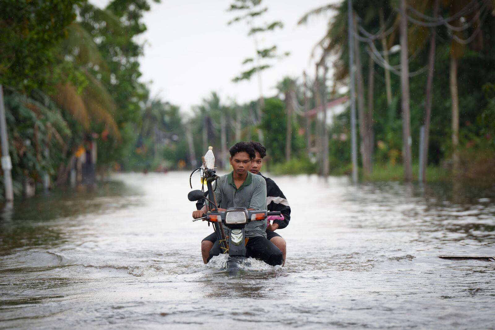 Residents ride on a self modified motorcycle through a road covered by flood water in Tumpat, outskirts of Kota Bahru, Malaysia, Tuesday, Dec. 3, 2024. (AP Photo/Vincent Thian)