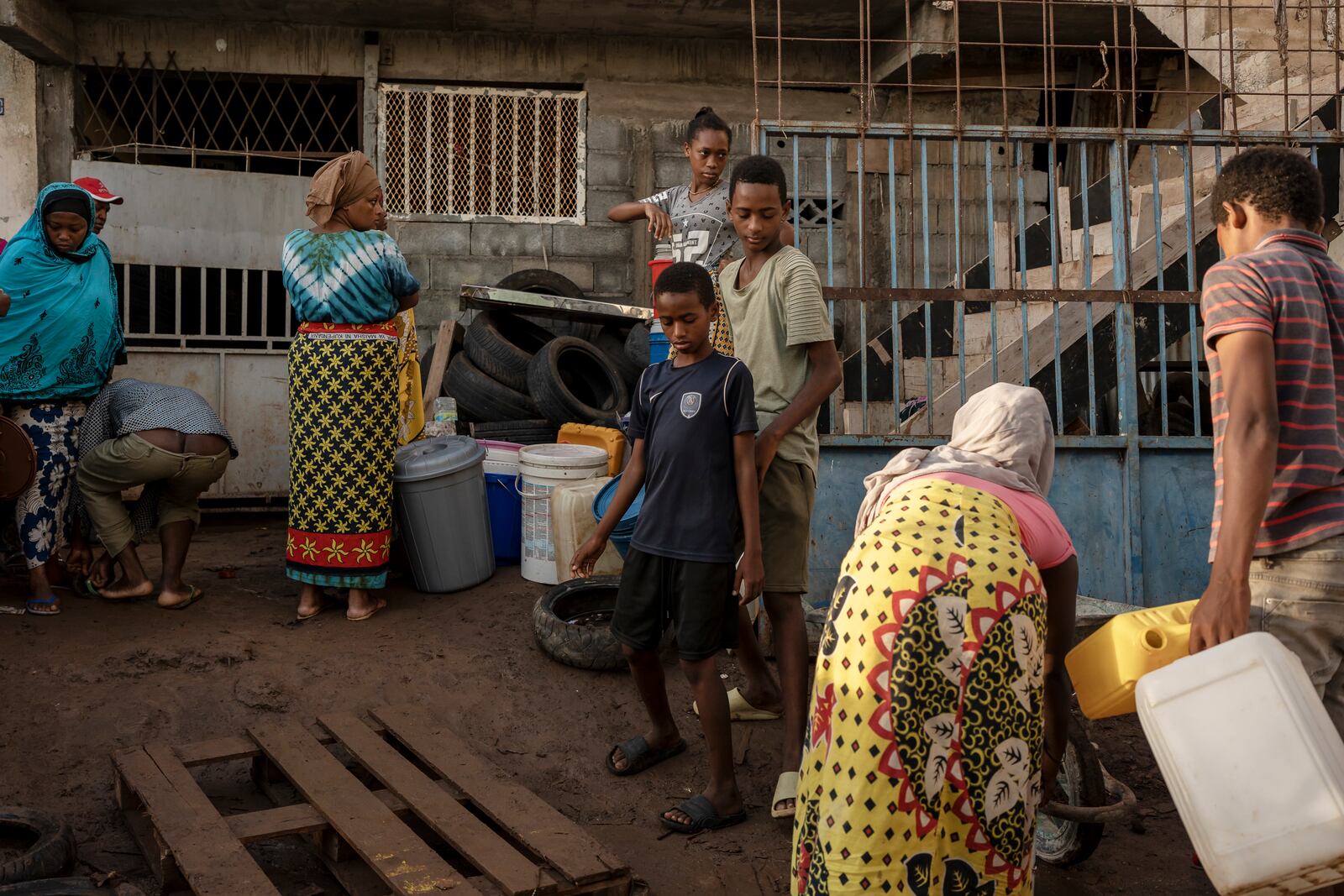 People get water from a well in the lower part of the Kaweni slum where they used to have tap water, on the outskirts of Mamoudzou, in the French Indian Ocean island of Mayotte Thursday, Dec. 19, 2024, after Cyclone Chido. (AP Photo/Adrienne Surprenant)