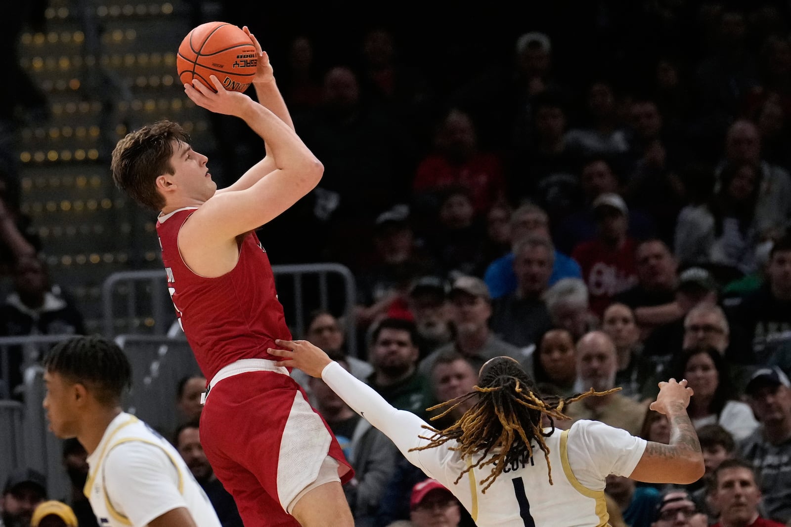 Miami (Ohio) guard Peter Suder, left, shoots over Akron guard Shammah Scott (1) in the second half of an NCAA college basketball game in the championship of the Mid-American Conference tournament, Saturday, March 15, 2025, in Cleveland, Ohio. (AP Photo/Sue Ogrocki)