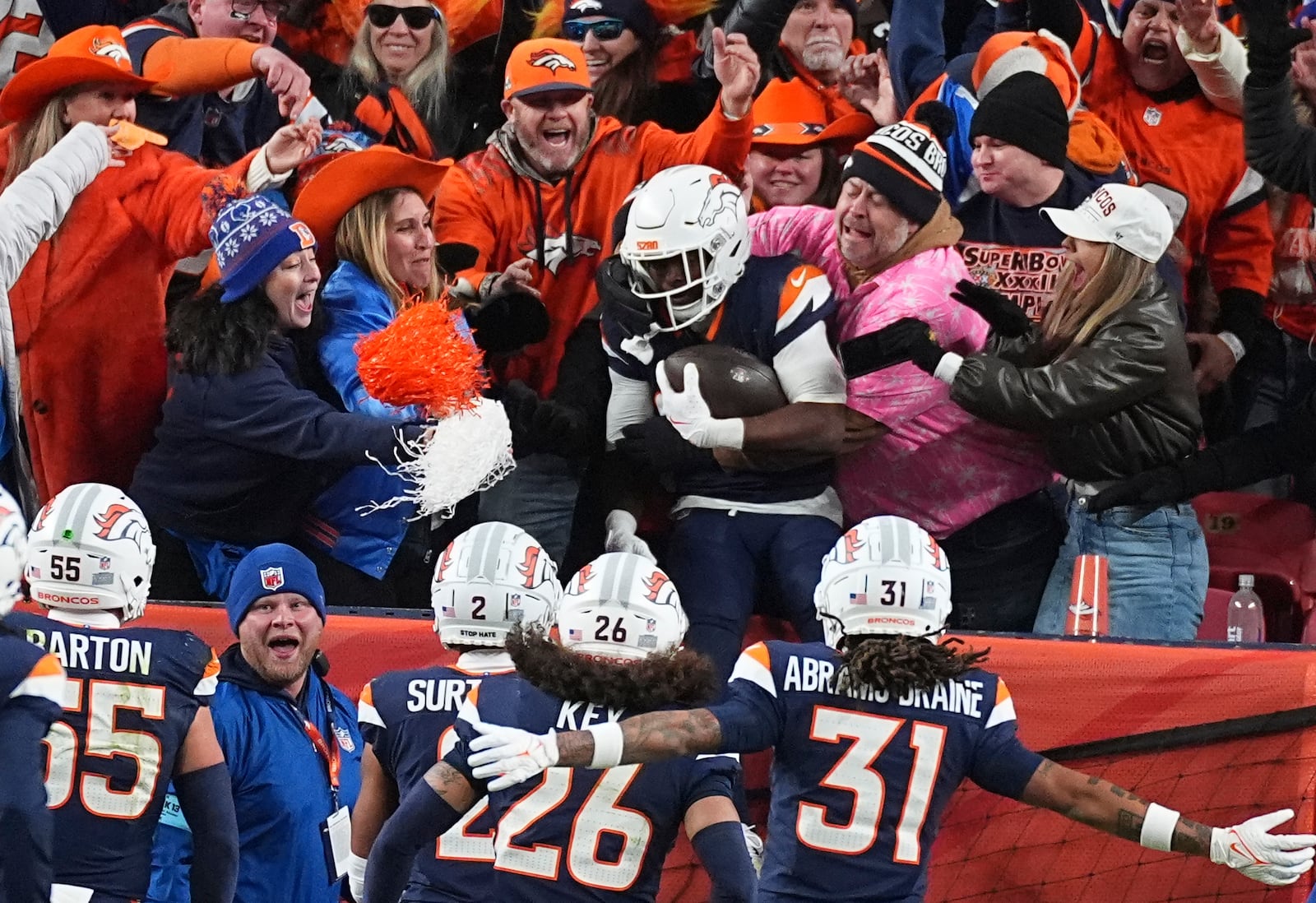 Denver Broncos cornerback Ja'Quan McMillian, back center, is congratulated by fans after returning an interception for a touchdown in the second half of an NFL football game against the Cleveland Browns, Monday, Dec. 2, 2024, in Denver. (AP Photo/David Zalubowski)