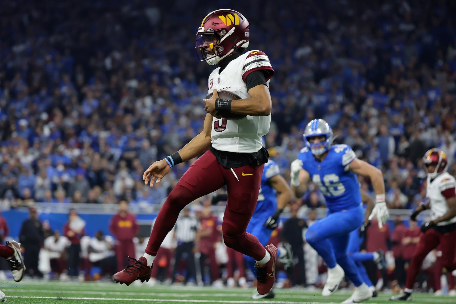 Washington Commanders quarterback Jayden Daniels (5) runs the ball as Detroit Lions linebacker Jack Campbell (46) pursues during the first half of an NFL football divisional playoff game, Saturday, Jan. 18, 2025, in Detroit. (AP Photo/Rey Del Rio)