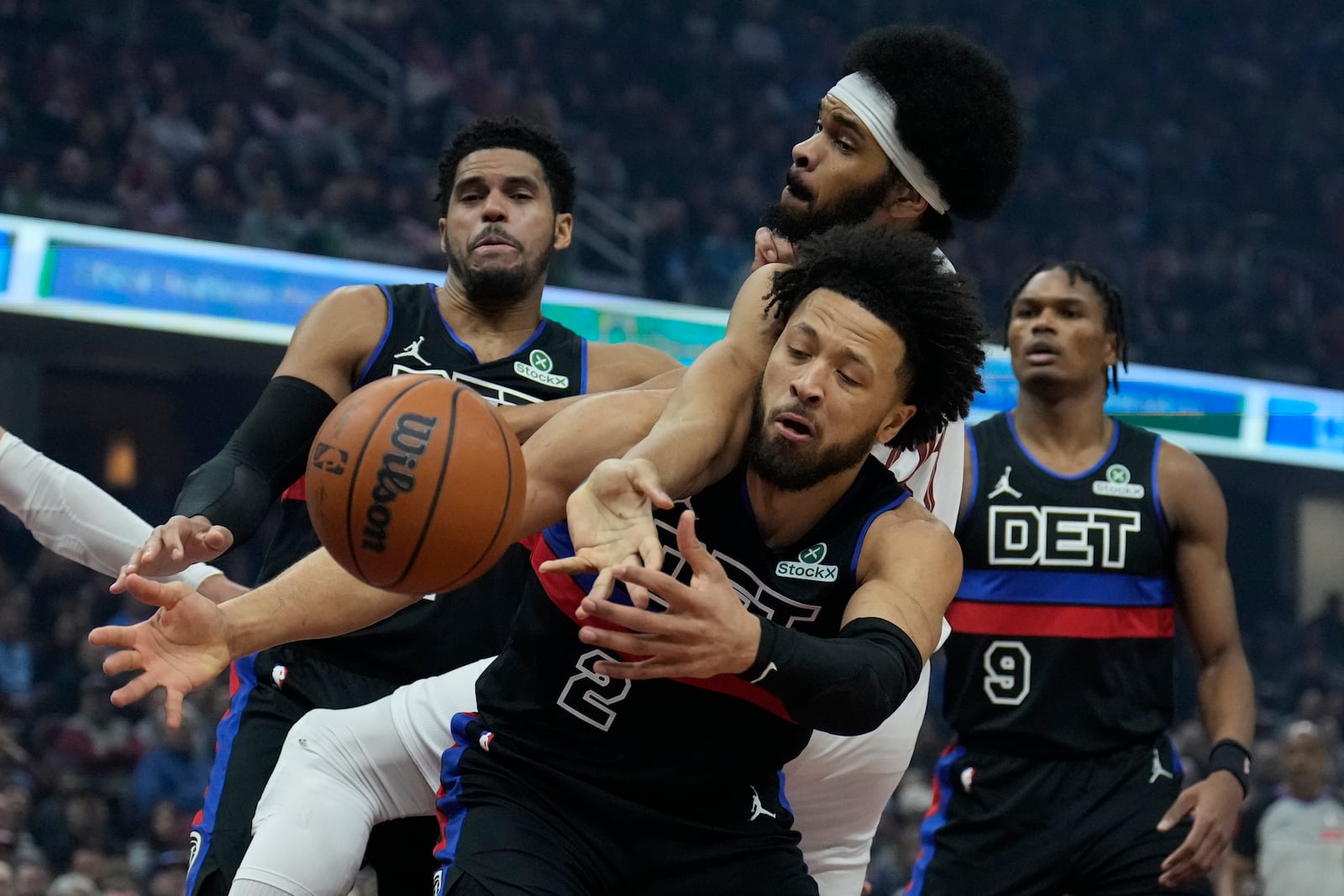 Detroit Pistons forward Tobias Harris, left, Cleveland Cavaliers center Jarrett Allen, center top, and Pistons' Cade Cunningham (2) reach for a rebound in the first half of an NBA basketball game, Monday, Jan. 27, 2025, in Cleveland. (AP Photo/Sue Ogrocki)