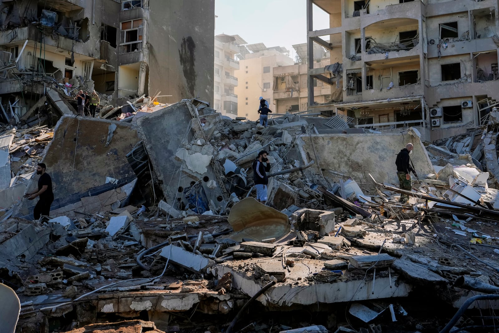 Residents check the site of an Israeli airstrike in Tayouneh, Beirut, Lebanon, Friday, Nov. 15, 2024. (AP Photo/Hassan Ammar)