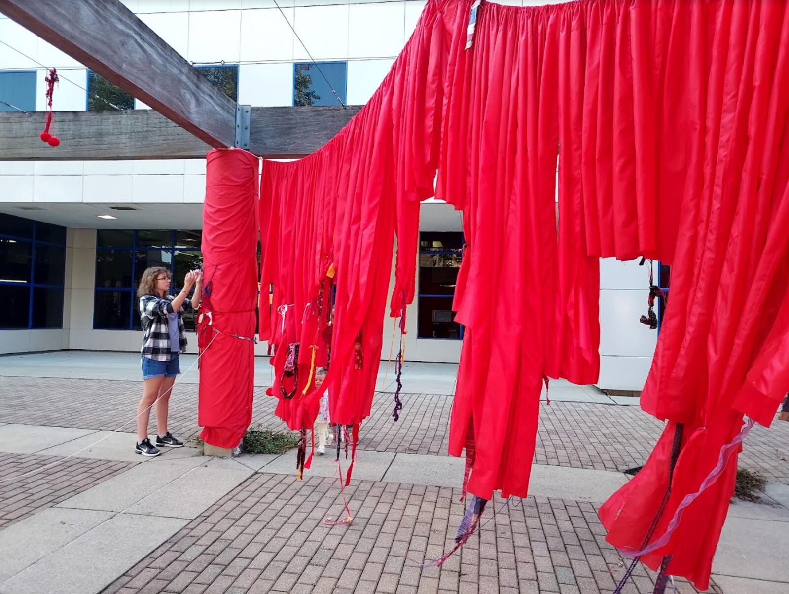 A "Pergola Pop Up" at the Fitton Center for Creative Arts' season launch party Aug. 18, 2023 was led by Cathy Mayhugh, director of exhibitions, and Moya Jones, lead artist. It includes nearly 200 yards of red fabric at the Monument Avenue Pergola and is on display through the end of the month. The idea is to draw attention to the area, Mayhugh said. CONTRIBUTED