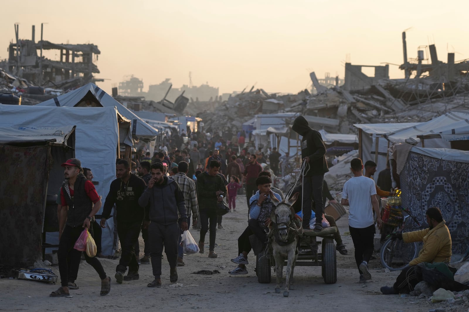 Palestinians walk amid the rubble of destroyed homes and buildings in Jabaliya, northern Gaza Strip on Friday, March 14, 2025. (AP Photo/Jehad Alshrafi)