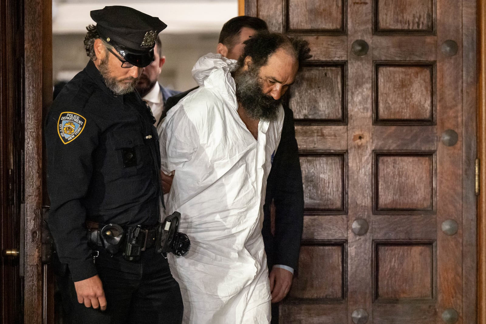 Ramon Rivera, a suspect arrested after multiple people were stabbed early Monday, is escorted out by NYPD officers at the NYPD 10th Precinct in New York, Monday, Nov. 18, 2024. (AP Photo/Yuki Iwamura)