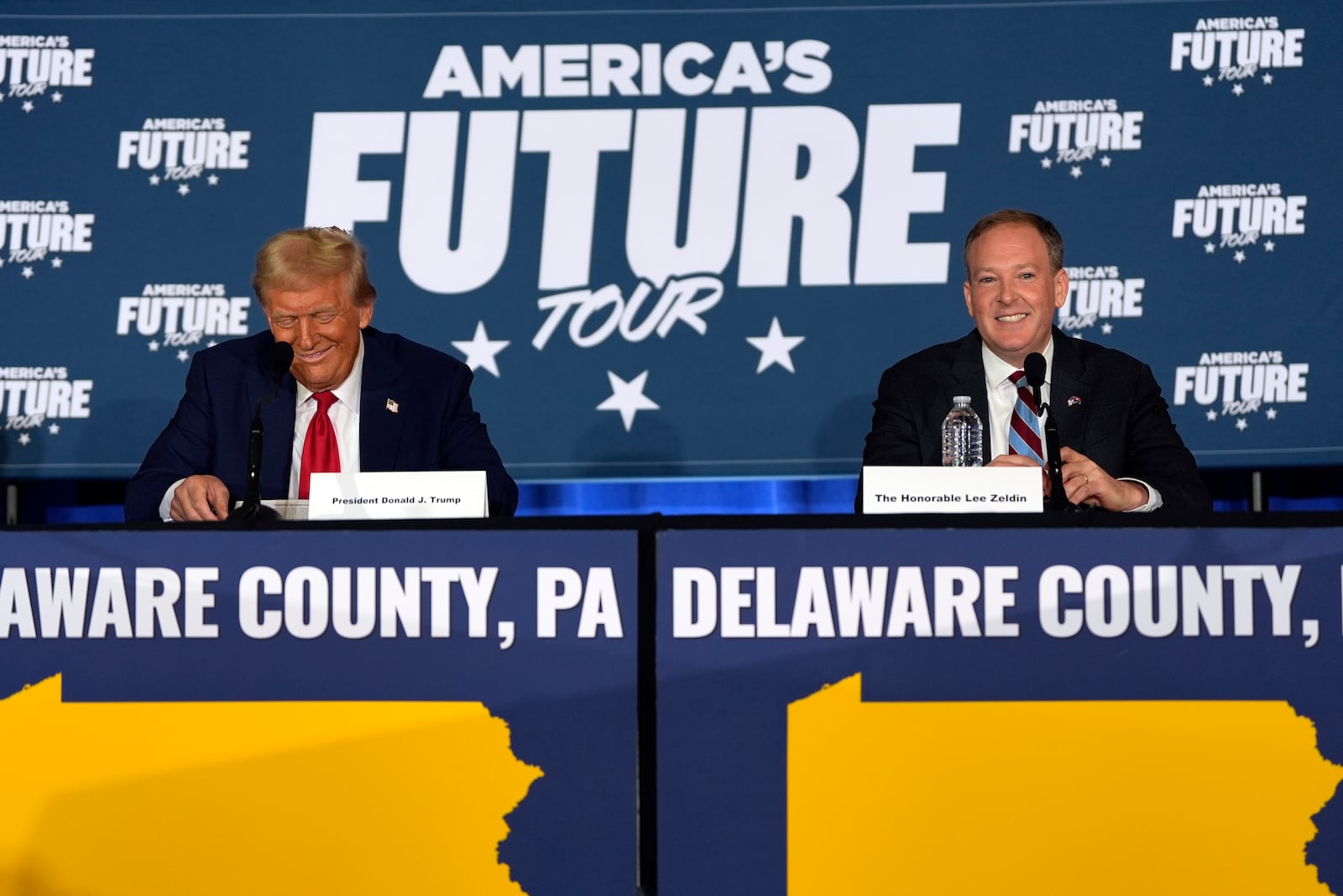 Republican presidential nominee former President Donald Trump smiles as former Rep. Lee Zelda, R-N.Y., watches during a roundtable at the Drexelbrook Catering & Event Center, Tuesday, Oct. 29, 2024, in Drexel Hill, Pa. (AP Photo/Julia Demaree Nikhinson)