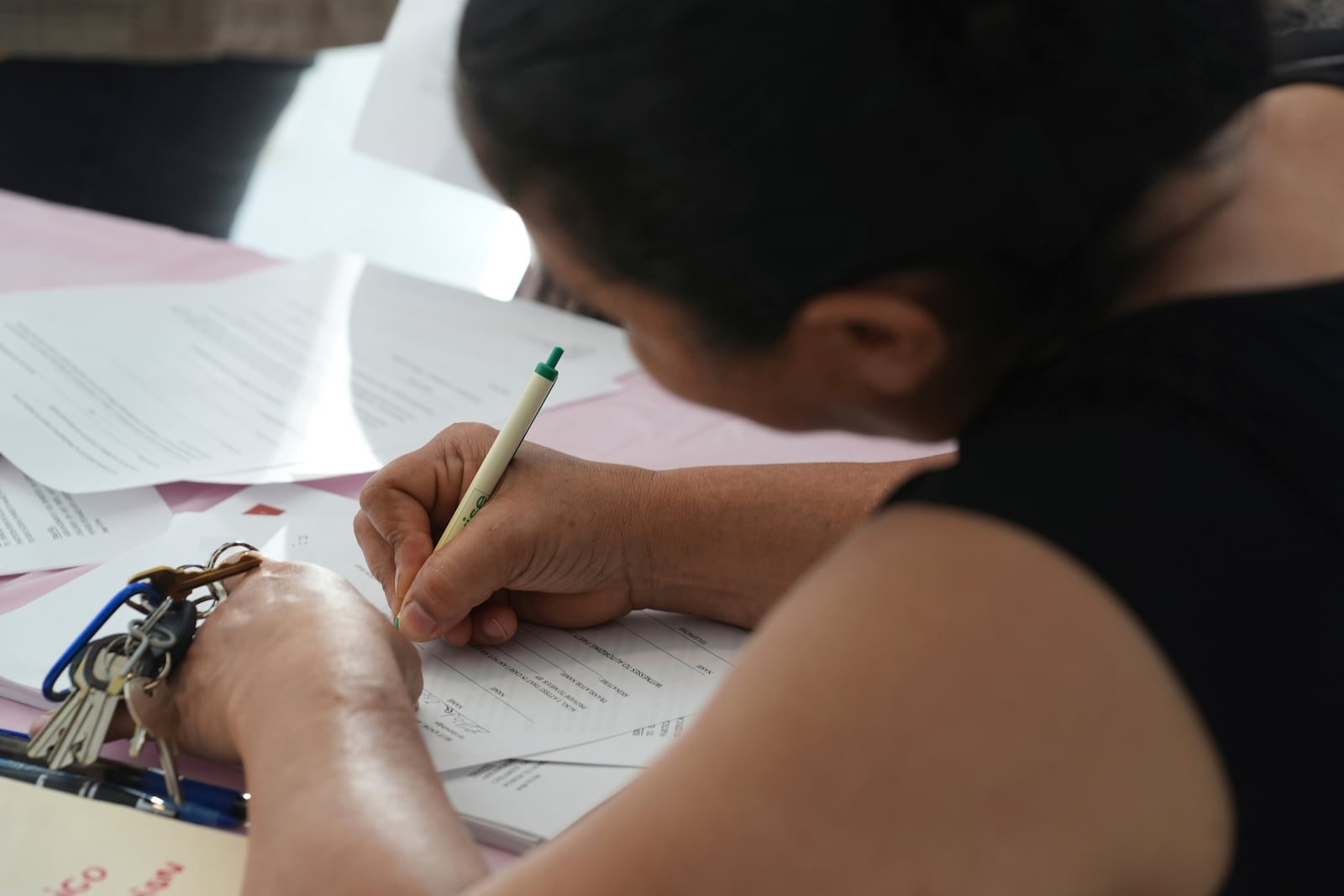 A young mother signs a document giving Nora Sandigo legal guardianship of her minor children if she is detained or deported by immigration authorities, Sunday, Jan. 19, 2025, in Miami. (AP Photo/Marta Lavandier,file)