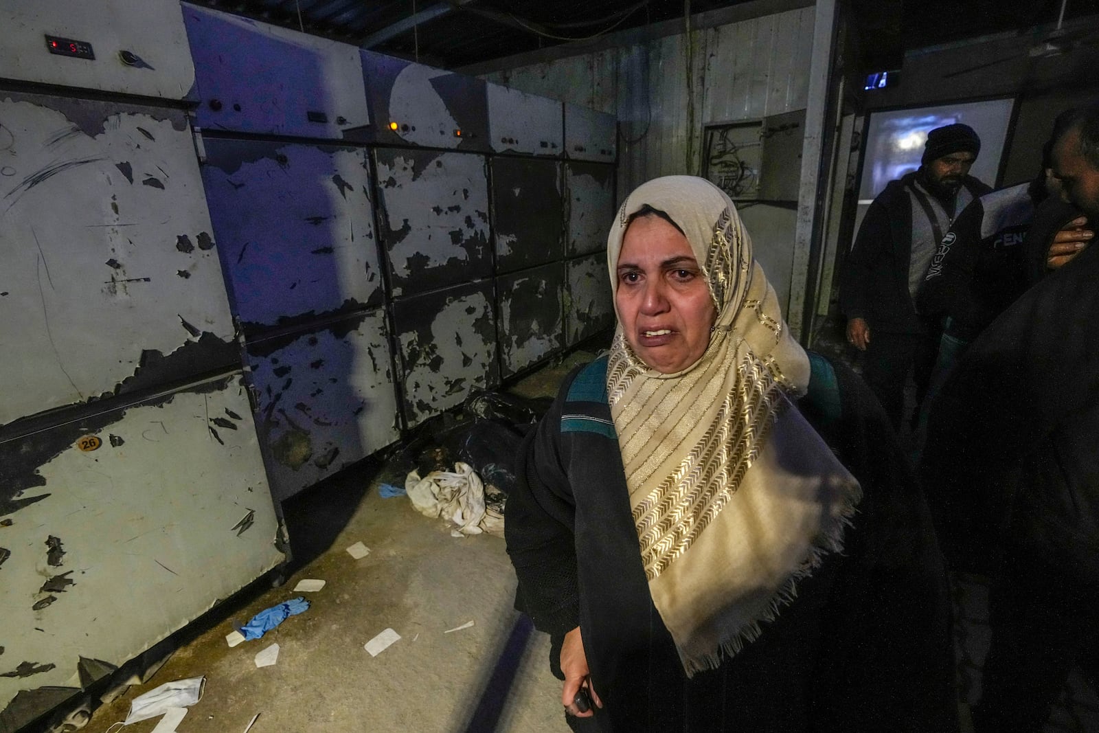 A woman leaves the morgue at Al-Mojtahed hospital in Damascus, Syria, on Wednesday, Dec. 11, 2024. Syrians are flocking to morgues, hoping to identify their slain loved ones who are missing or may have been imprisoned under the rule of President Bashar Assad, whose government collapsed over the weekend. (AP Photo/Hussein Malla)