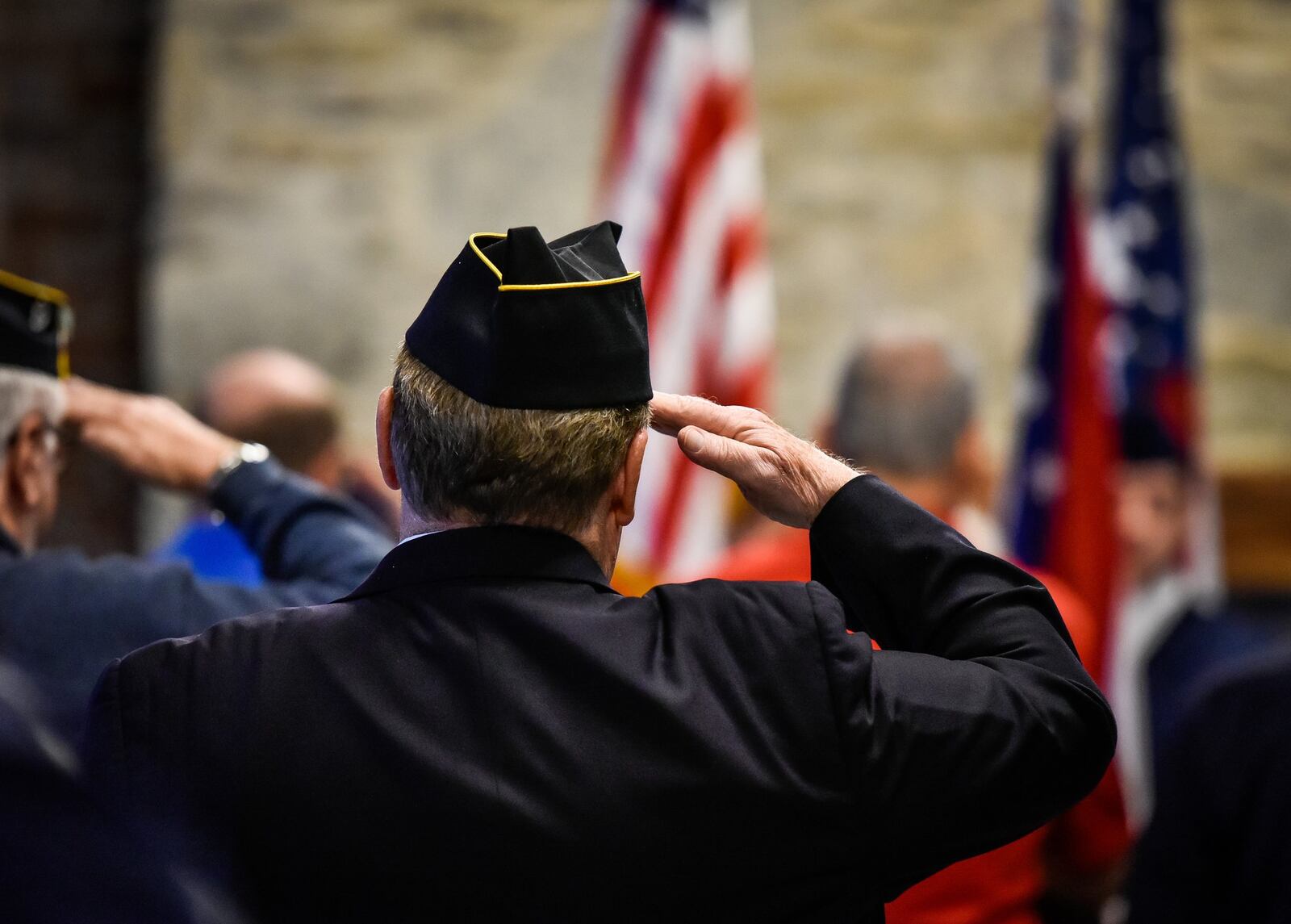 Veterans stand at attention during the singing of the National Anthem at the annual Butler County Veterans Day program Monday, Nov. 12.