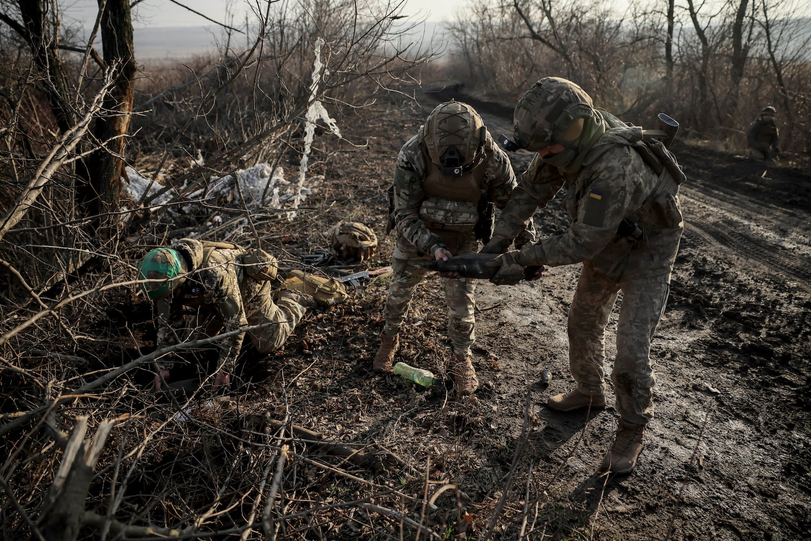 Ukrainian servicemen collect damaged ammunition on the road at the front line near Chasiv Yar town, in Donetsk region, Ukraine, Ukraine, Friday, Jan. 10, 2025. (Oleg Petrasiuk/Ukraine's 24th Mechanised Brigade via AP)