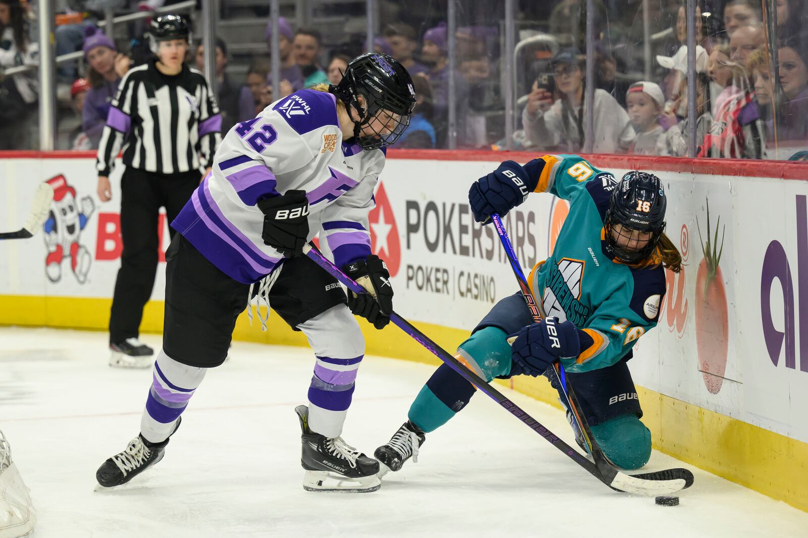 Minnesota defenseman Claire Thompson and New York defenseman Lauren Bernard battle for the puck during the second period of a PWHL game between the New York Sirens and the Minnesota Frost, at Little Caesars Arena, in Detroit, Sunday, March 16, 2025. (David Guralnick/Detroit News via AP)