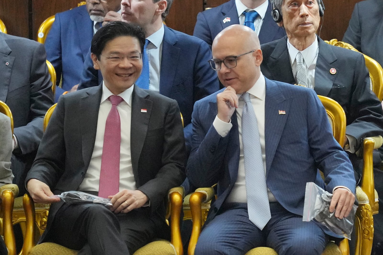 Singaporean Prime Minister Lawrence Wong, left, talks with his Serbian counterpart Milos Vucevic, as they attend the swearing in ceremony of Indonesia's new President Prabowo Subianto at the parliament building in Jakarta, Indonesia, Sunday, Oct. 20, 2024. (AP Photo/Tatan Syuflana)