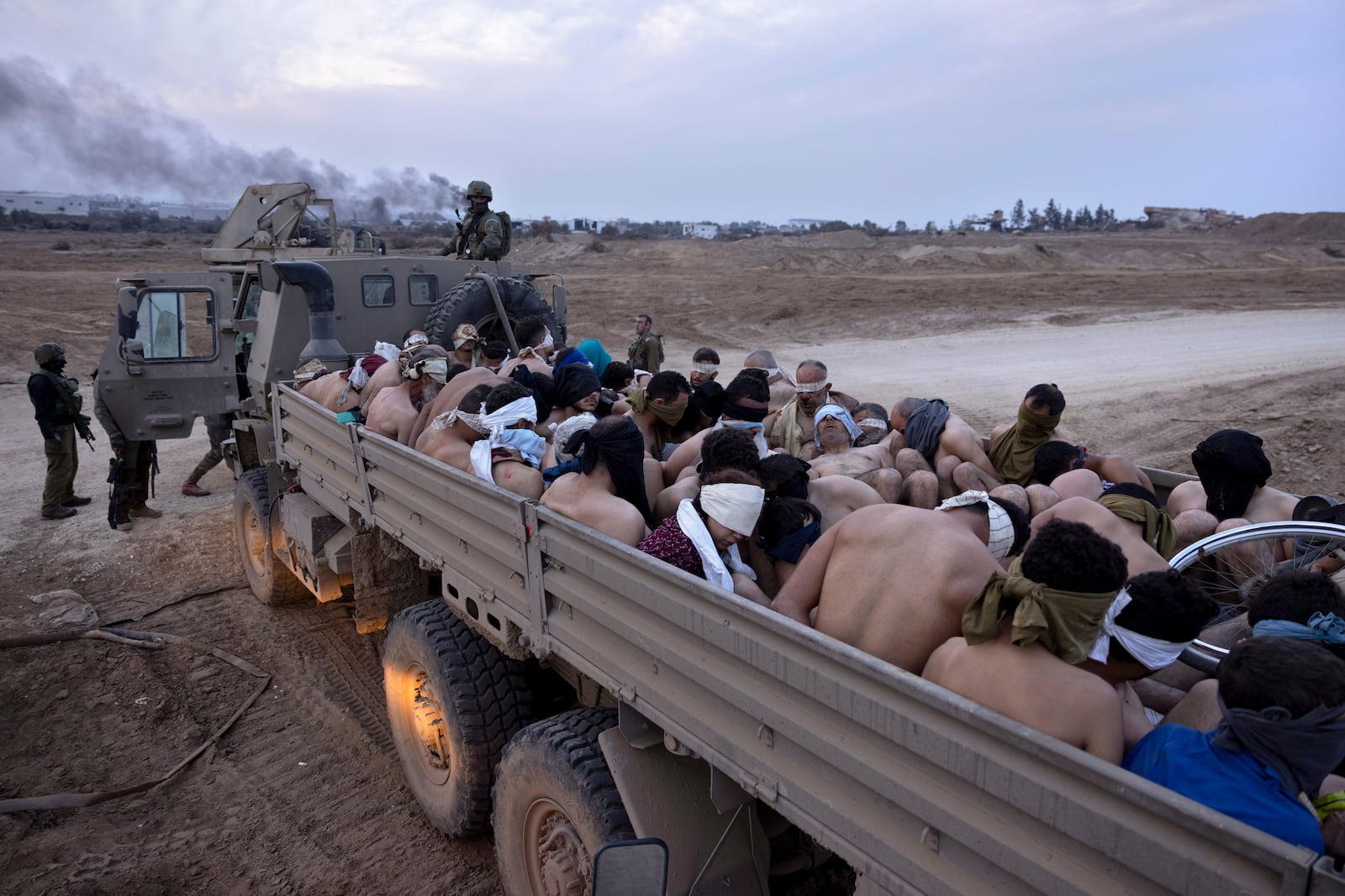 FILE - Israeli soldiers stand by a truck packed with bound and blindfolded Palestinian detainees in Gaza, on Dec. 8, 2023. (AP Photo/Moti Milrod, Haaretz, File)