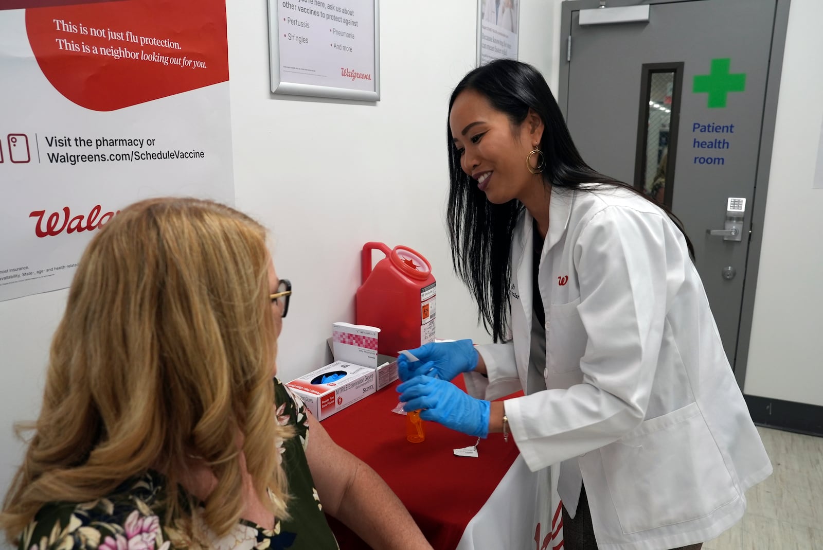 FILE - Anh Nguyen prepares to administer a COVID-19 vaccine for Kelly Vazquez at a pharmacy in New York, Sept. 24, 2024. (AP Photo/Mary Conlon, File)