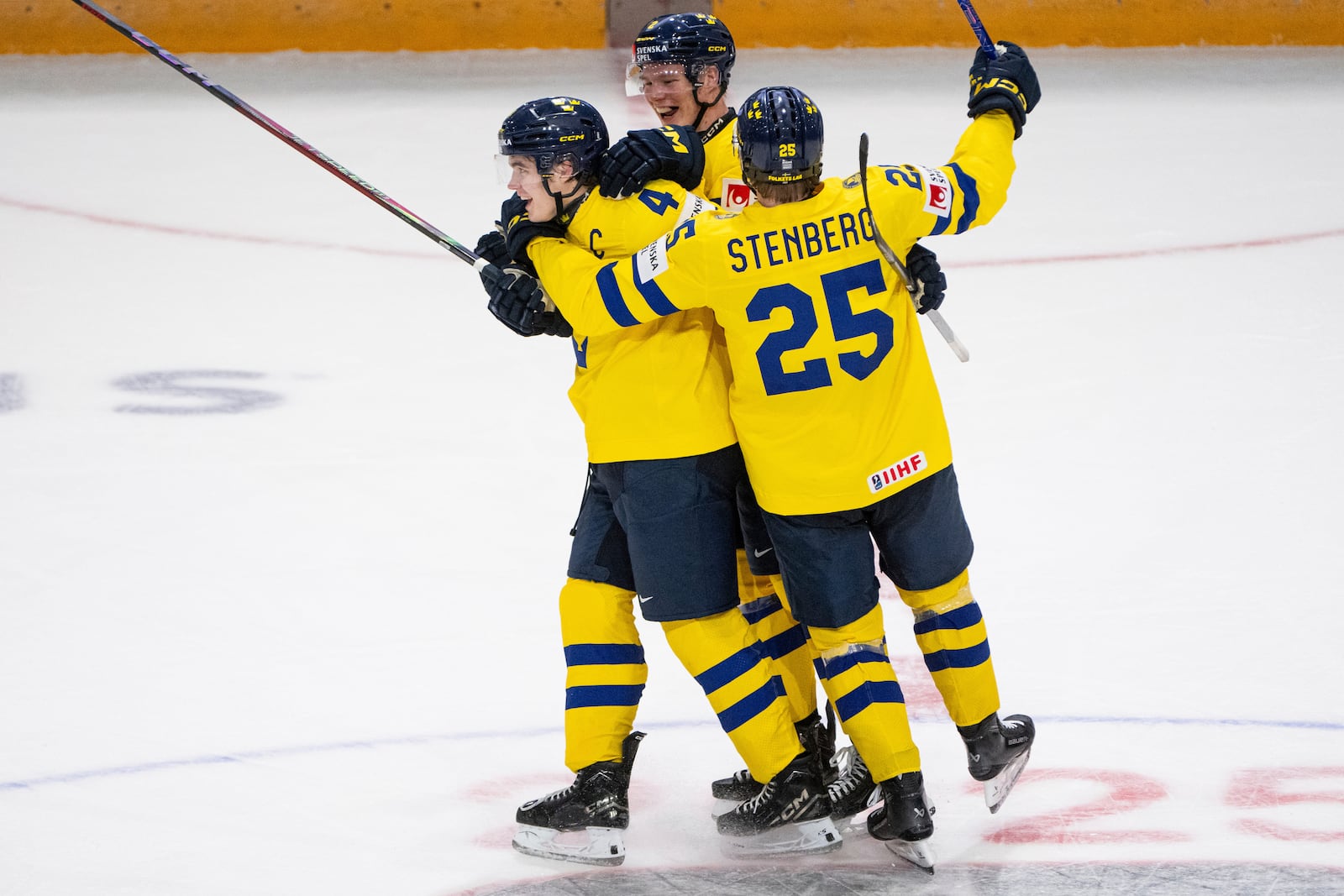 Sweden forward Otto Stenberg (25) and teammate Rasmus Bergqvist (2) celebrate Axel Sandin-Pellikka's (4) hat-trick goal during third period IIHF World Junior Hockey Championship preliminary round action against Slovakia, in Ottawa, Thursday, Dec. 26, 2024. (Spencer Colby/The Canadian Press via AP)