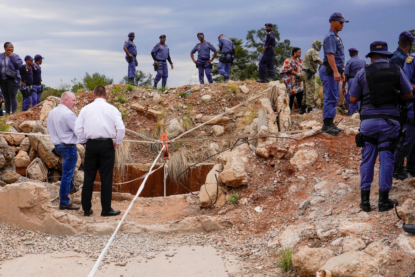 FILE - Police officers and private security personnel stand by the opening of a reformed gold mineshaft where illegal miners are trapped in Stilfontein, South Africa, Friday, Nov.15, 2024. (AP Photo/Denis Farrell, File)