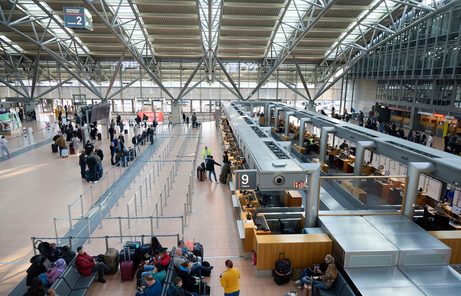 Passengers stand in front of counters at Hamburg Airport, Germany Sunday, March 9, 2025. (Georg Wendt/dpa via AP)