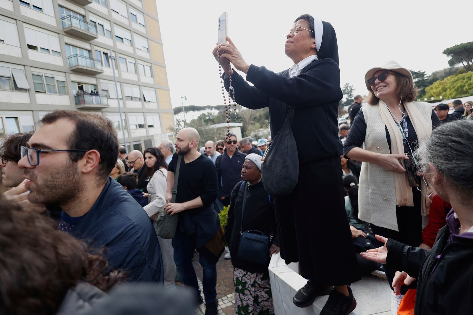 Faithful and nuns wait a Pope Francis appearing at a window of the Agostino Gemelli Polyclinic in Rome, Sunday, March 23, 2025, for the first time after being admitted on Feb. 14 with bronchitis that afterward worsened into bilateral pneumonia. (AP Photo/Riccardo De Luca)