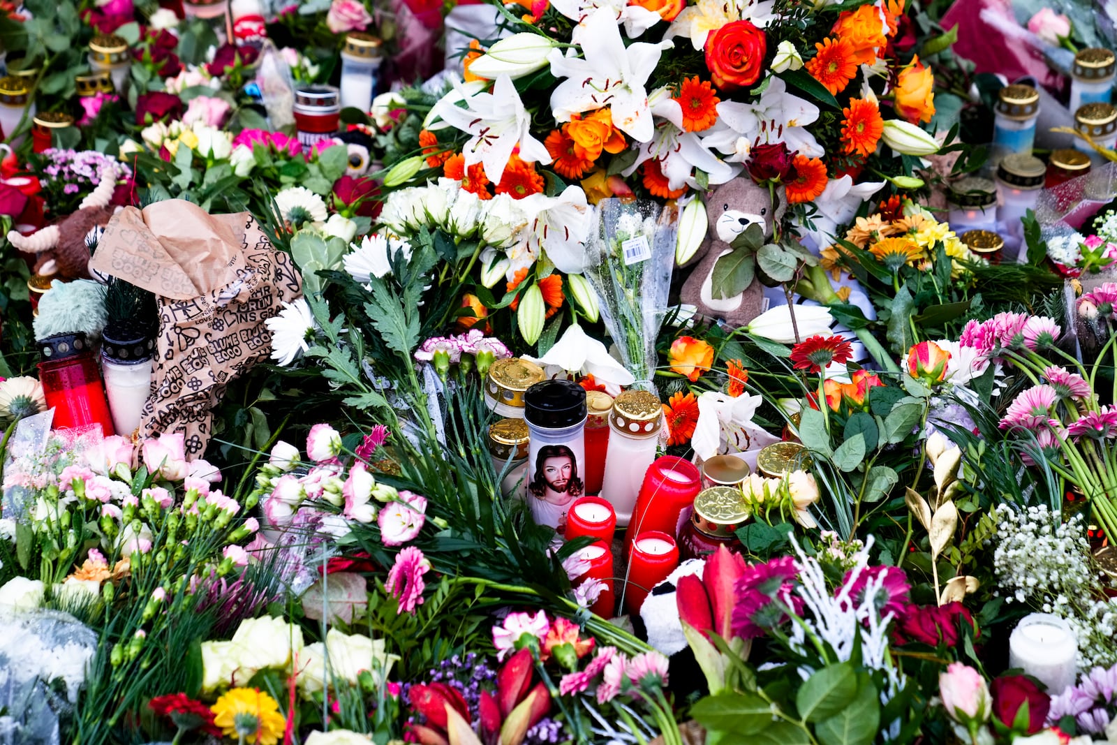 Flowers and candles laid down in front of the Johannis church close to the Christmas market, where a car drove into a crowd on Friday evening, in Magdeburg, Germany, Sunday, Dec. 22, 2024. (AP Photo/Ebrahim Noroozi)