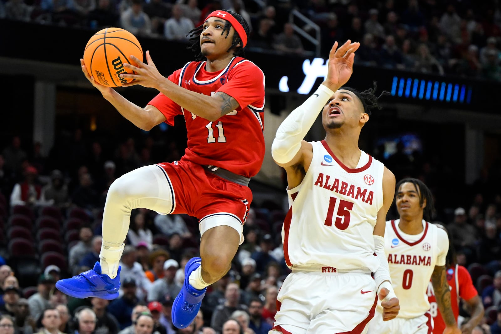 Robert Morris guard DJ Smith (11) drives to the basket passt Alabama forward Jarin Stevenson (15) in the first half in the first round of the NCAA college basketball tournament, Friday, March 21, 2025, in Cleveland. (AP Photo/David Richard)