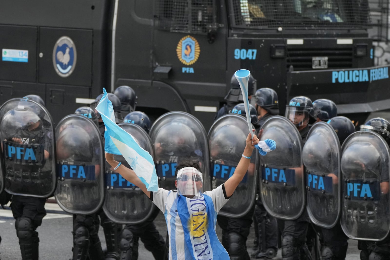 A soccer fan joins retirees protesting for higher pensions and against austerity measures implemented by President Javier Milei's government in Buenos Aires, Argentina, Wednesday, March 12, 2025. (AP Photo/Natacha Pisarenko)