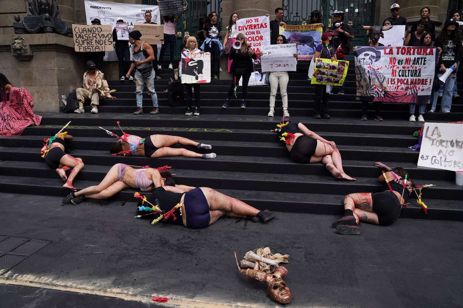 FILE - Animal rights activists smeared with fake blood and donning banderillas to depict bulls stabbed in bullfights, protest against bullfighting, in Mexico City, Feb. 14, 2024. (AP Photo/Marco Ugarte, File)