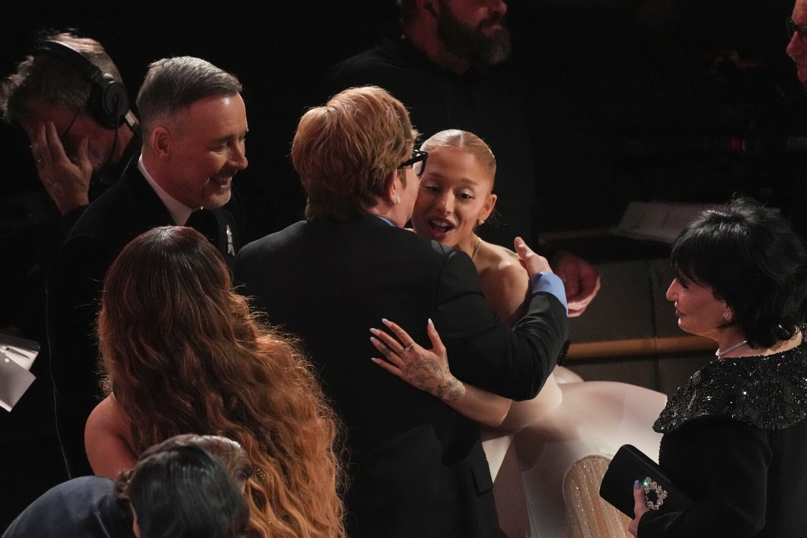 Elton John, left, and Ariana Grande embrace in the audience during the Oscars on Sunday, March 2, 2025, at the Dolby Theatre in Los Angeles. (AP Photo/Chris Pizzello)