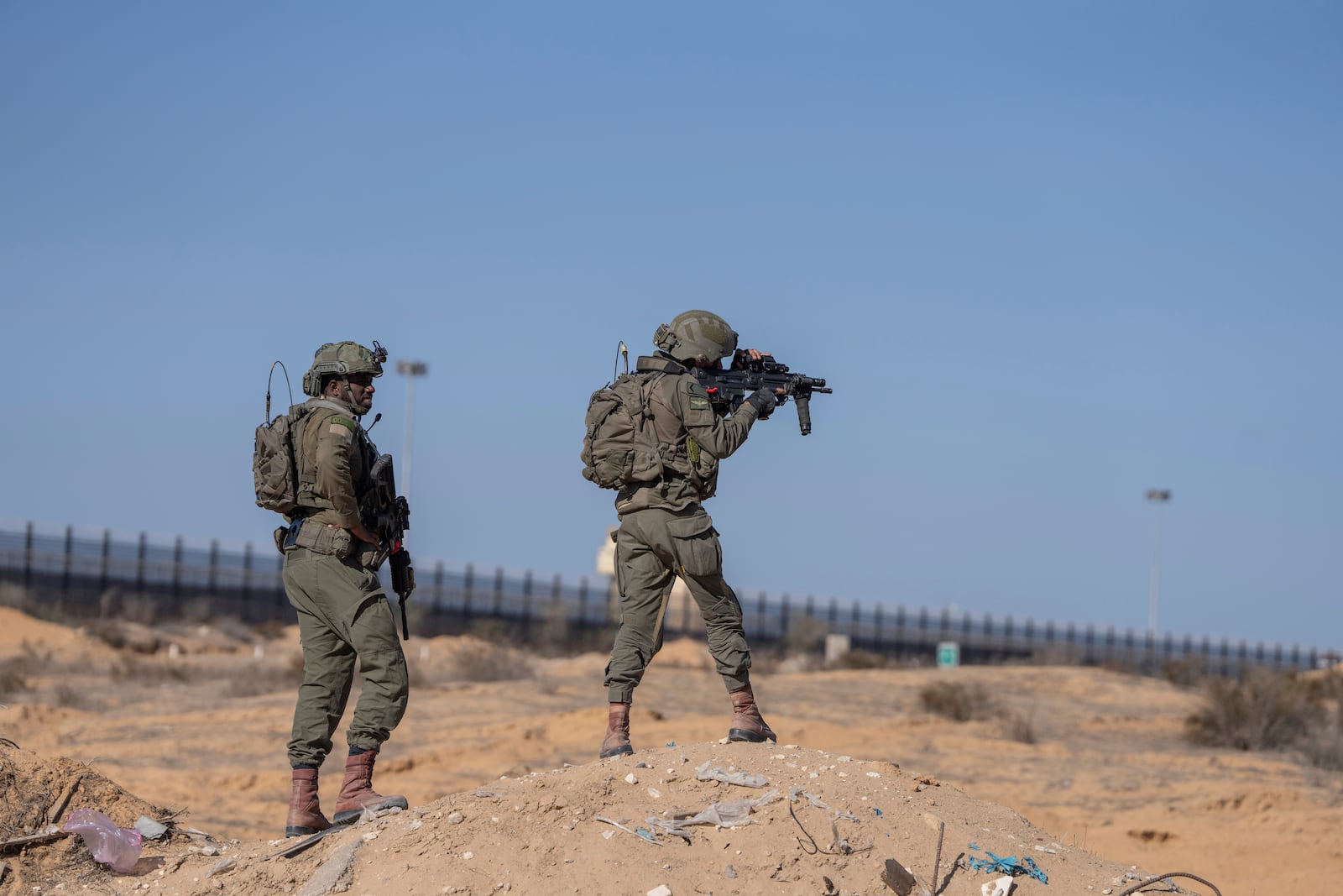 Israeli soldiers stand guard on the Palestinian side of the Kerem Shalom crossing as reporters tour the area in the Gaza Strip, Thursday, Dec. 19, 2024. (AP Photo/Ohad Zwigenberg)