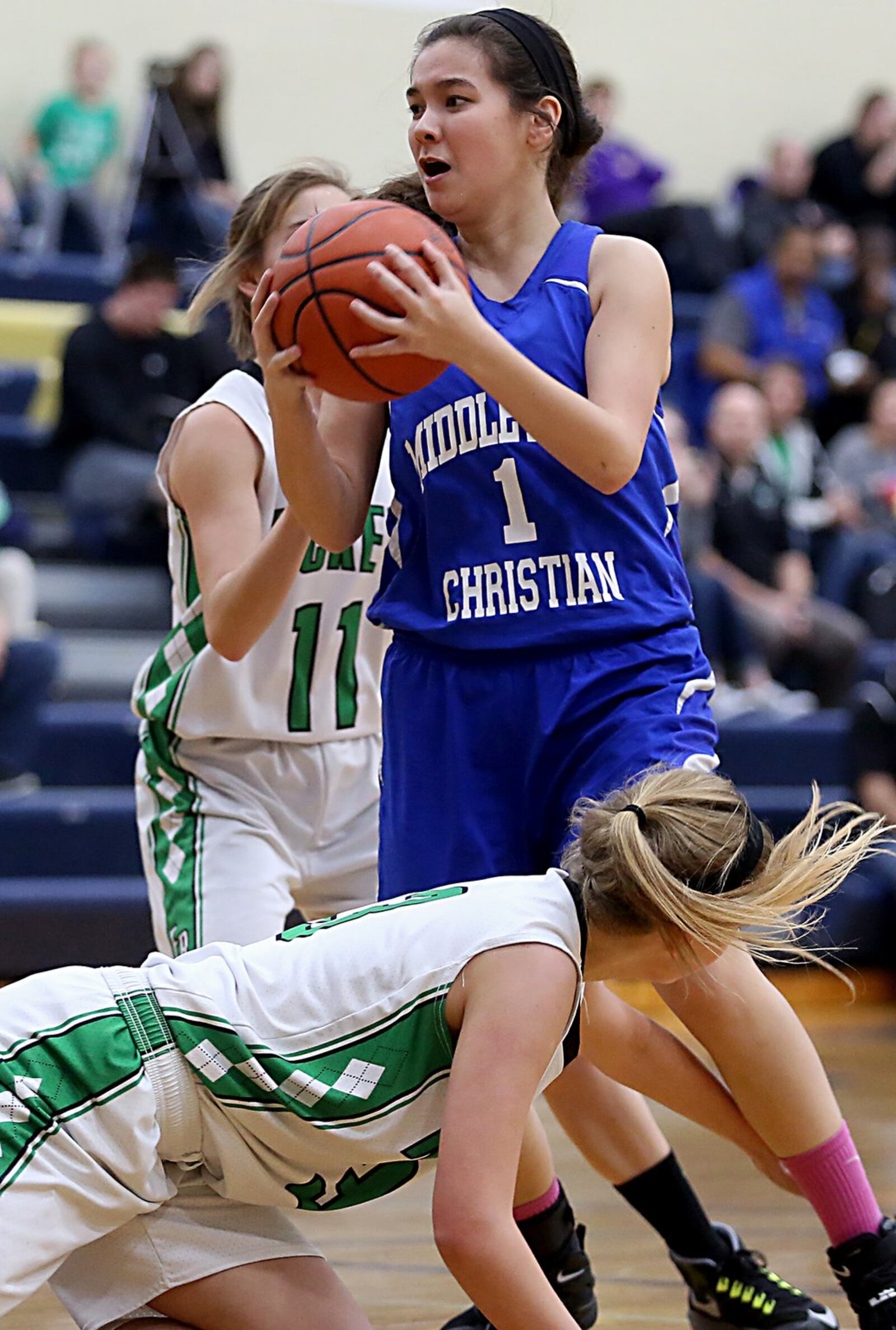 Middletown Christian’s Tiffany Kim grabs a rebound between Fayetteville’s Cecilia Murphy (11) and Savannah Lynch on Tuesday night during a Division IV sectional game at Monroe. CONTRIBUTED PHOTO BY E.L. HUBBARD