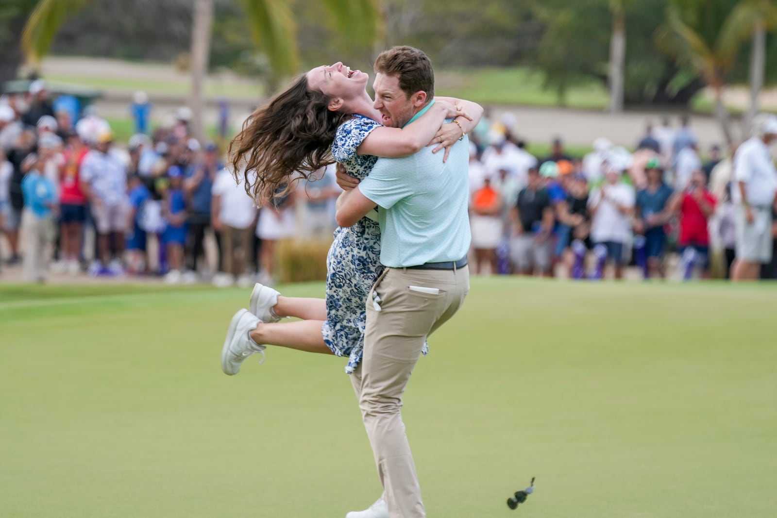 Brian Campbell, of the United States, embraces his girlfriend Kelsi McKee after winning the Mexico Open golf tournament in Puerto Vallarta, Mexico, Sunday, Feb. 23, 2025. (AP Photo/Fernando Llano)